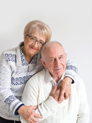 Portrait of a happy elderly couple in white clothes on a white background