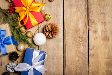 Gifts and Christmas decorations, Christmas tree branch on a wooden background. The concept of Christmas, winter holidays, new year. Flat lay, top view