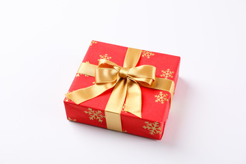 Beautiful gift box with golden bow on white background, space for text
