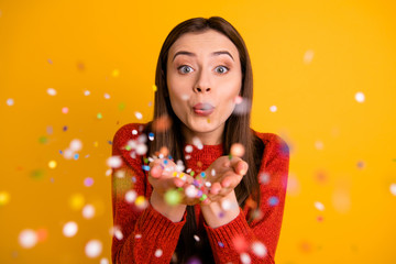 Photo of cheerful cute nice charming youngster millennial blowing confetti at you from her hands...