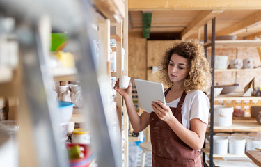 Craftswoman with tablet computer in art studio 