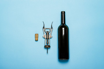 Bottle of wine and corkscrew on a blue background. Concept sommelier, wine tasting, wine...