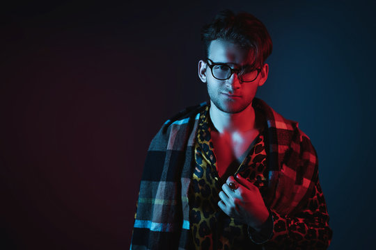 Fashion art neon light studio portrait of stylish man model with leopard shirt and glasses. Glamour light.