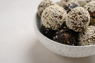 Homemade energy balls close up in a light vase on a white background