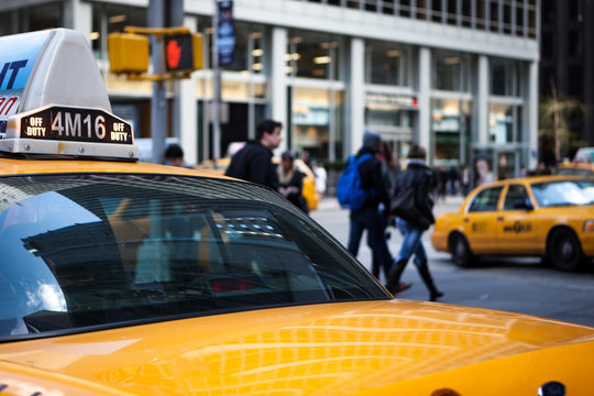 NYC taxi on the streets of New York. A candid street scene viewed  over the rear of a yellow taxi cab in midtown Manhattan.