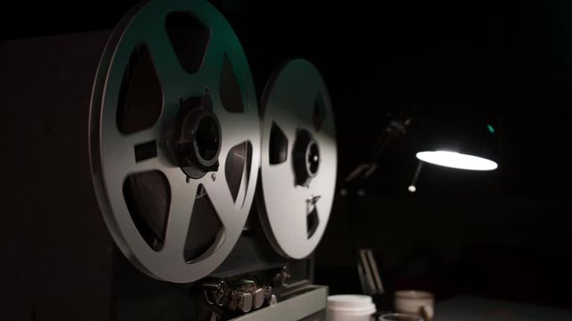  Retro Analog Quarter Inch Tape Recorder Being Operated in a Darkened Room