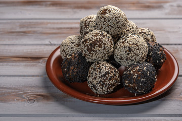 Homemade energy balls on a brown plate on a wooden background