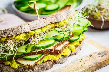 Poster Grote veggie sandwich met tofu, groenten, spruitjes en guacamole. Gezond veganistisch voedselconcept. © vaaseenaa