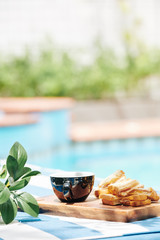 Cup of coffee and sandwiches on wooden board outdoors