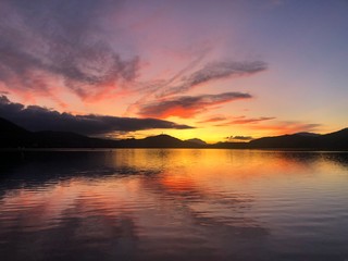 Fototapeta na wymiar sunset on lake with pink and oragnge, ducks 