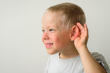 Little boy with hearing gesture