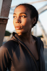 Photo of african american young woman looking aside while working out