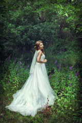 Obraz na płótnie Canvas Wedding walk. Bride next to a green tree