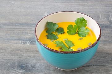Cream of pumpkin soup with pumpkin seeds, parsley and dry bread