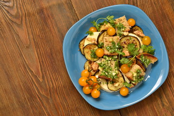 Eggplant with mozzarella, croutons, cilantro pesto and walnuts, top view, copy space