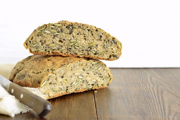 Homemade whole grain bread with seeds on a wooden background, copy space