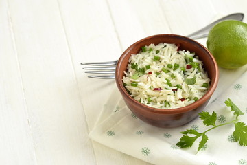 Basmati rice with lime, cilantro and garlic in ceramic bowl,  copy space