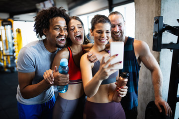 Fototapeta na wymiar Group of sportive people in a gym taking selfie. Concepts about lifestyle and sport in fitness club