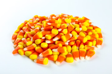 Bunch of candy corn sweets as sybol of Halloween hoiday on textured background with a lot of copy space for text. Flat lay composition for all hallows eve. Top view shot.