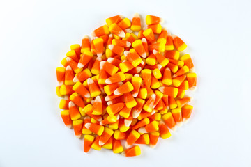 Bunch of candy corn sweets as sybol of Halloween hoiday on textured background with a lot of copy space for text. Flat lay composition for all hallows eve. Top view shot.