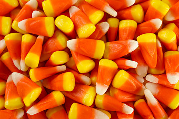 Bunch of candy corn sweets as sybol of Halloween hoiday on textured background with a lot of copy...
