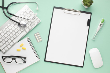 Healthcare accessories with clipboard and modern devices over green background