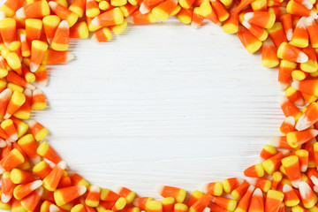 Bunch of candy corn sweets as sybol of Halloween hoiday on textured background with a lot of copy space for text. Flat lay composition for all hallows eve. Top view shot.