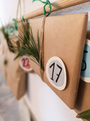 close up of a handmade advent calendar hanging from a wooden stick