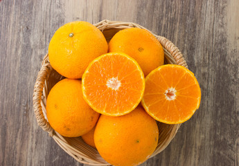 Oranges in a beautiful basket on wood table