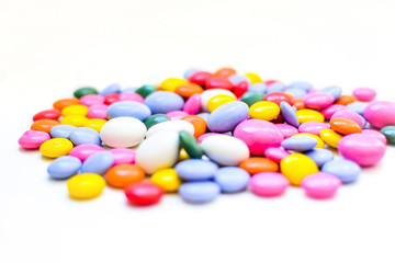 Chocolate dragee in a multi-colored glaze. Bokeh. Selective focus.