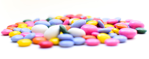 Chocolate dragee in a multi-colored glaze. Panoramic photo. Bokeh. Selective focus.