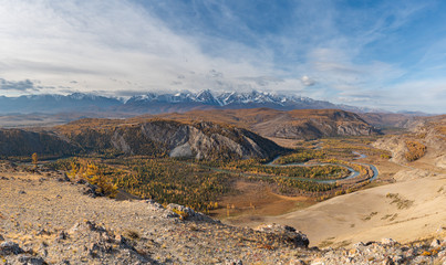 Winding river on a background of mountains and autumn trees