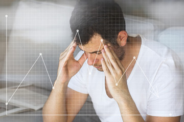 handsome businessman in white t-shirt thinking on the grey sofa in living room with free copy space for your text