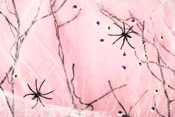 Pink halloween background with spider web, spiders and monster eyes