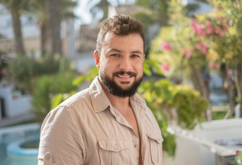 Forty years old man portrait in garden looking at camera and smirking