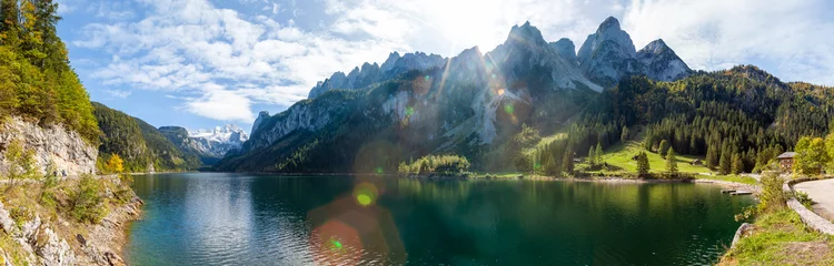 Fotobehang Beroemde Lake Gosau en Gosaukamm met Mount Dachstein. De zon staat op het punt zich achter de hoge toppen te verschuilen, terwijl de herfst op het punt staat zijn intrede te doen met alle levendige kleuren rond het meer en de heuvels. © djr-photography