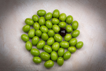 green and a black olives on a white background, olives campaign,healthy food
