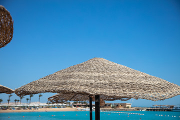 Straw sunshade umbrellas on the beach