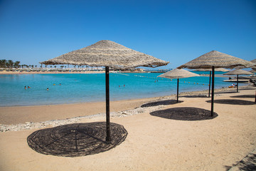 Straw sunshade umbrellas on the beach
