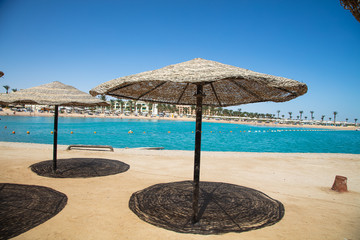 Straw sunshade umbrellas on the beach