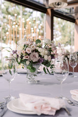 A beautiful wedding bouquet of fresh flowers in a crystal vase on the holiday table.