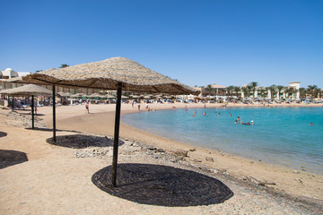 Straw sunshade umbrellas on the beach