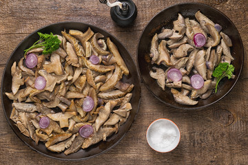 Delicious fried mushrooms in pan on table