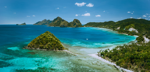 Palawan, Philippines. Las Cabanas beach with rocky mountains and village El Nido in background