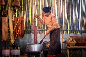 Craftsmen of Thai Silk. Older women dye silk with colors from volcanic soil. Phu fabric dyeing...