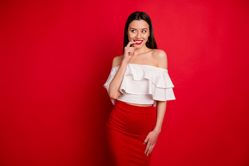 Portrait of magnificent lady having thoughts with fingers touching teeth pondering wearing...