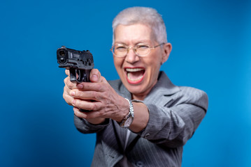 Old business lady shooting with her weapon, screaming