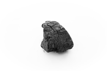 black charcoal on white background. a porous black solid, consisting of an amorphous form of carbon, obtained as a residue when wood, bone, or other organic matter is heated in the absence of air.