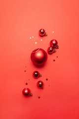 Creative Christmas poster of red balls and glitter red stars on red background. Flat lay, top view, copy space