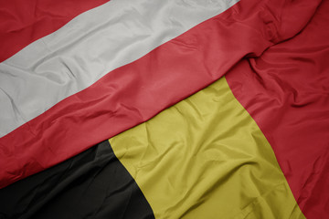 waving colorful flag of belgium and national flag of austria.